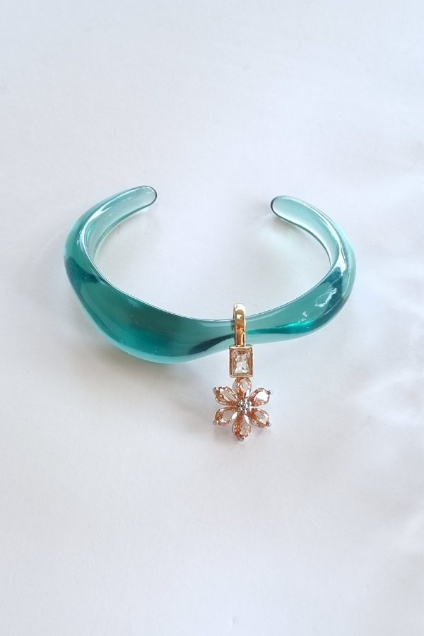 צמיד פתוח תכלת שקוף בתצוגת סטודיו עם תליון פרח קריסטלי